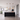 Drie Flora hanglampen met amberglas en messing boven een zwart kookeiland
